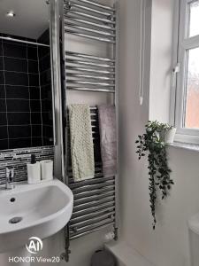 a bathroom with a sink and a towel rack at Olive and Carols Walsall Stays in Walsall