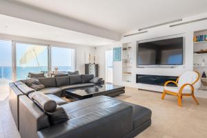 sala de estar con sofá de cuero y TV en Villa Mediterraneo by Mallorca House Rent, en Cala Murada