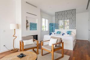 1 dormitorio blanco con 1 cama y 2 sillas en Villa Mediterraneo by Mallorca House Rent, en Cala Murada