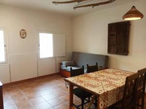 a dining room with a table and a couch at El Olivo in Torre del Compte