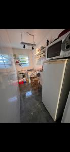 a kitchen with a white refrigerator and a table at Studio Fabriketa in Novo Hamburgo