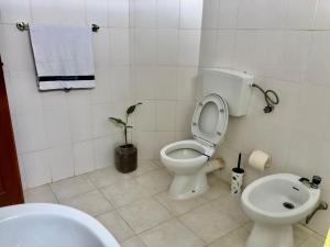 a bathroom with a toilet and a sink at Tarrafal Ecodécor Rooms in Tarrafal