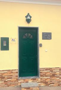 a green door on the side of a building at Casa da Avó Pipa in Reguengos de Monsaraz