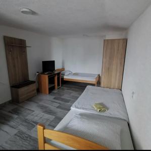 um pequeno quarto com uma cama e uma secretária em Gostionica Kod Krlje em Nova Topola