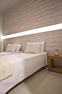 two beds with white sheets and pillows in a room at Xanthippi Hotel in Souvala