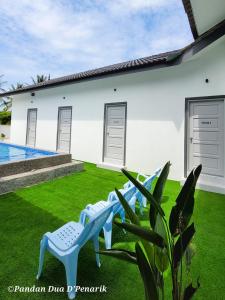 a group of blue chairs in the yard of a house at Pandan Dua D'Penarik in Kampong Ru Sepuloh +8 photos