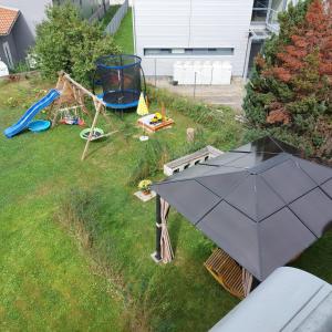 una vista aérea de un patio trasero con una sombrilla y un parque infantil en Ferienwohnung Lehmann, en Staufen