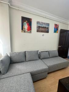uma sala de estar com um sofá e pinturas na parede em 1+1 Flat in Fatih Aksaray em Istambul