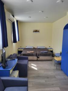 a bedroom with a bed and a couch and a tv at Къща за гости Бовъ in Gara Bov