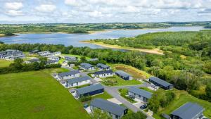 eine Luftansicht eines Wohngebäudes neben einem Fluss in der Unterkunft Periwinkle Lodge, 3 Roadford Lake Lodges in Lifton