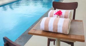 a table with a flower on it next to a pool at Starlit Suites Shirdi in Nighoj