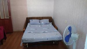 a small bedroom with a bed and a fan at Дом-House в Vadul lui Voda in Vadul lui Vodă