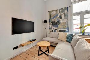 sala de estar con sofá y TV de pantalla plana en Lion Apartments - Azzuro Premium Loft with 2 Bedr en Sopot