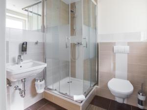 uma casa de banho com um chuveiro, um WC e um lavatório. em Hotel & Restaurant Wiggers em Bad Oldesloe