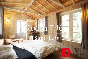 sypialnia z łóżkiem w pokoju z drewnianymi ścianami w obiekcie Saku Cafe w mieście Daigo