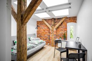 a living room with a brick wall and a table at Wygodne pokoje w Gliwicach in Gliwice