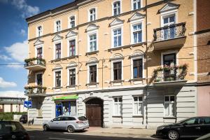 duży budynek z zaparkowanymi przed nim samochodami w obiekcie Wygodne pokoje w Gliwicach w mieście Gliwice