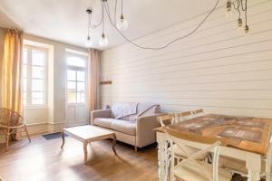 salon z kanapą i stołem w obiekcie Le rustique Chic tout confort w mieście Châteauroux