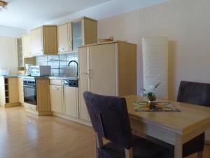 Apartment-Haus Am Jakobsweg في بوتسن: مطبخ مع طاولة خشبية وطاولة وكراسي