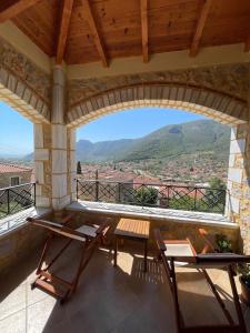 Un patio con dos sillas y una mesa en un balcón. en Panorama Stonehouse, en Leonidio