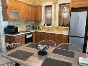cocina con mesa de madera y nevera blanca en Panorama Stonehouse, en Leonidio 17 fotos más