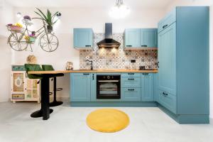 a kitchen with blue cabinets and a wooden table at Apartman Paulina in Rovinj