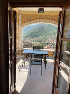 Una mesa y sillas en un balcón con vista. en Panorama Stonehouse, en Leonidio