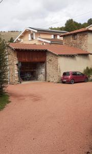 un coche rojo estacionado frente a un edificio en Le Clos du Jubin, en Saint-Forgeux