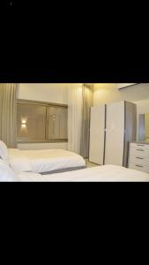 a bedroom with two beds and a refrigerator at شاليهات ورد المساء in Taif
