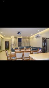 a room with tables and chairs and a living room at شاليهات ورد المساء in Taif