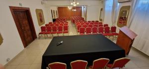 an auditorium with a black table and red chairs at Hotel Galicja SPA Wieliczka in Wieliczka