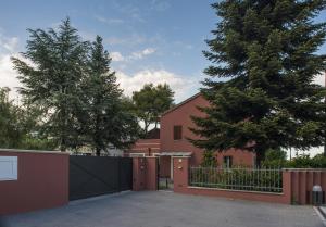 una cerca frente a una casa con un árbol en Casale Simbeni, en Misano Adriatico