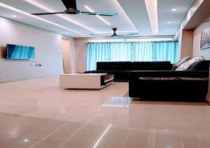 a living room with a couch and a ceiling fan at Staeg Hill View 2BHK - 602 in Indore