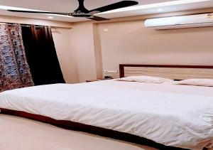 um quarto com uma cama e uma ventoinha de tecto em Staeg Hill View 2BHK - 602 em Indore
