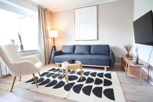 ein Wohnzimmer mit einem blauen Sofa und einem Tisch in der Unterkunft Homefy Wohlfühl-Apartment, mit Parkplatz, Balkon und Garten in Essen
