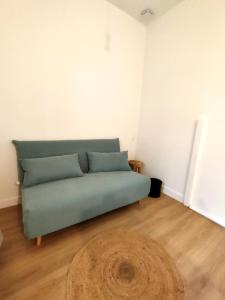 a green couch in a room with a wooden floor at Modern Flat Historic Center in Bordeaux