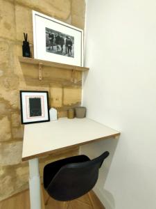 a desk with a black chair next to a wall at Modern Flat Historic Center in Bordeaux