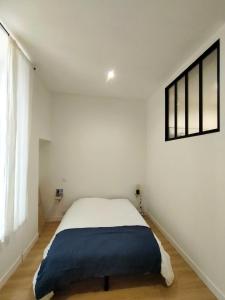 a white bedroom with a bed with a blue blanket at Modern Flat Historic Center in Bordeaux