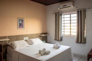 1 dormitorio con 1 cama con toallas en Inácios Hotel ltda, en Redenção