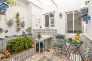 a patio with a table and chairs and potted plants at Palacete Fabian 1 in Ítrabo