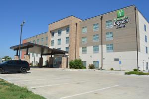 a building with a car parked in a parking lot at Holiday Inn Express & Suites - Liberal, an IHG Hotel in Liberal