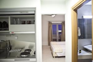 a room with a kitchen and a bedroom with a sink at Xanthippi Hotel in Souvala