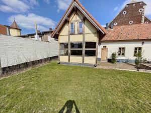 une maison avec un panneau x dans l'herbe dans l'établissement Begijnhof 4, à Saint-Trond