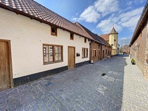 brukowana ulica z budynkami i kościołem w obiekcie Begijnhof 4 w mieście Sint-Truiden