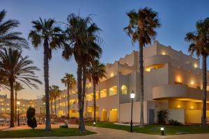 a building with palm trees in front of it at ALEGRIA Cabo De Gata in Retamar