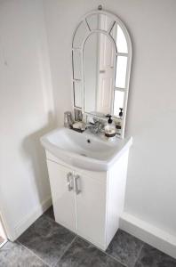 uma casa de banho com um lavatório branco e um espelho. em The Cubley Retreat em Sheffield