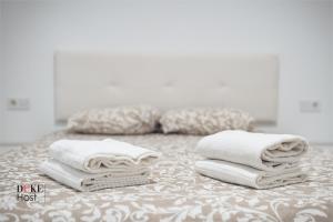 un mucchio di asciugamani seduti sopra un letto di Castellana Norte Ml8 a Madrid
