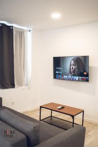 een woonkamer met een bank en een tv aan de muur bij Castellana Norte Ml8 in Madrid