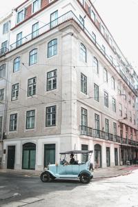una vecchia auto blu parcheggiata di fronte a un edificio di The House on the Pink Street in Lisbon a Lisbona