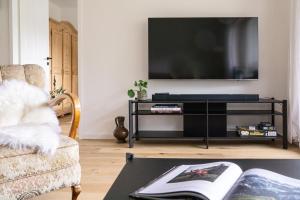 a living room with a tv and a table at Servus O´gau Apartments in Oberammergau